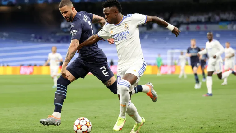 Kyle Walker and Vinicius Jr tussle for the ball in a Champions League match